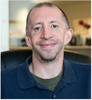 Tom Hamel headshot, white man looking at the camera and smiling